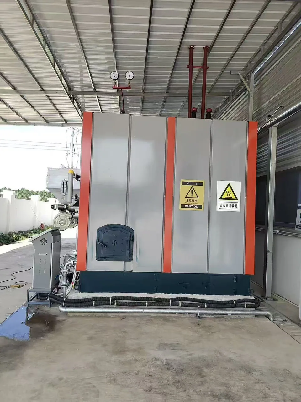 End view of the LHS biomass steam generator enclosure with inspection door and pressure gauges in Bangladesh