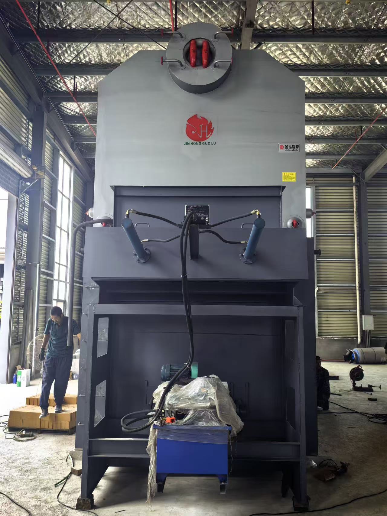 Front view of the Kenya biomass boiler showing hydraulic cylinders, hoses and fuel-handling equipment
