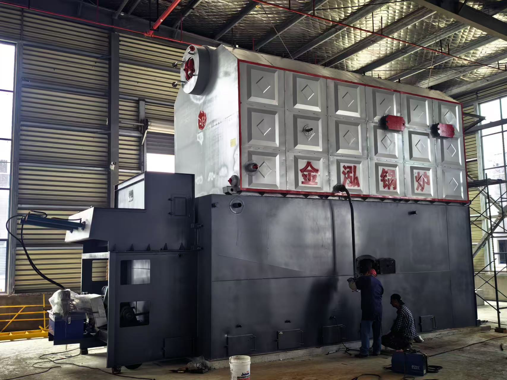 Side view of the Kenya DZH biomass boiler showing metal cladding and access openings