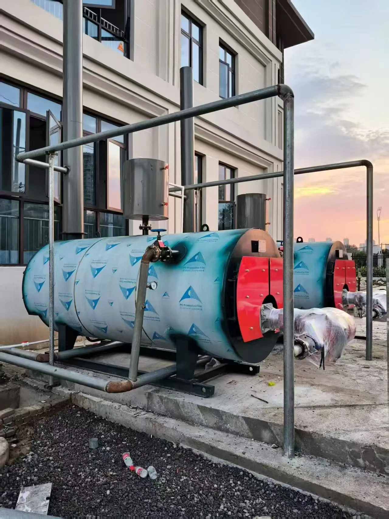 Side view of two CWNS hot water boilers and site pipework during installation in Vietnam